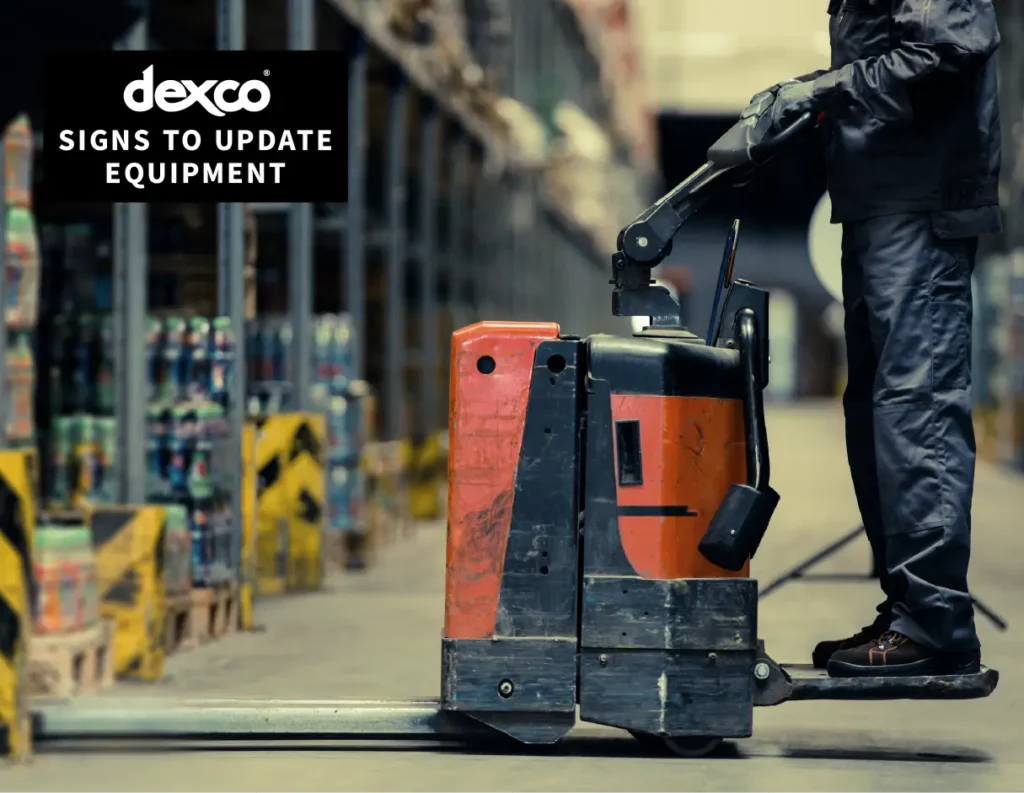 A worker positioned on a forklift , lifting heavy equipment in a warehouse setting