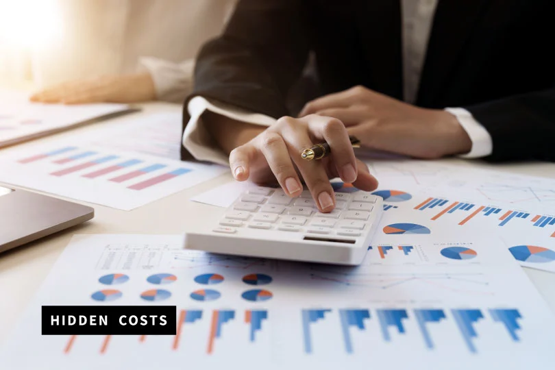 A person typing into a calculator to asses costs